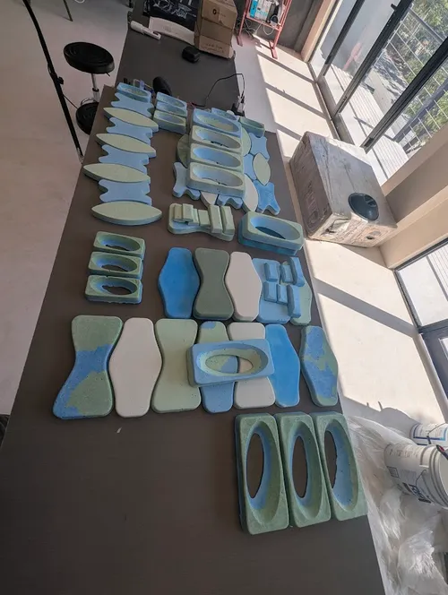 Piezas de molde de prueba en distintos colores y geometrías, sobre una mesa de taller.